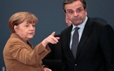 Germany's Chancellor Angela Merkel talks to Greece's Prime Minister Antonis Samaras as they arrive for a forum with Greek entrepreneurs in Athens