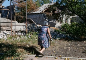 A local woman passes by near her residence which was damaged during fighting between the Ukrainian army and pro-Russian separatists, in Pervomayskoe