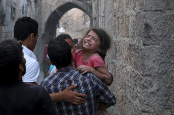 An injured girl reacts at a site hit by what activists said were barrel bombs dropped by forces of Syria's President Bashar al-Assad, in the old city of Aleppo June 7, 2015. REUTERS/Abdalrhman Ismail