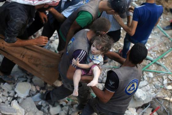 A medic carries an injured girl that survived under debris from what activists said was barrel bombs dropped by forces loyal to Syria's President Bashar Al-Assad in Douma, eastern Ghouta, near Damascus, Syria August 22, 2015. REUTERS/Bassam Khabieh