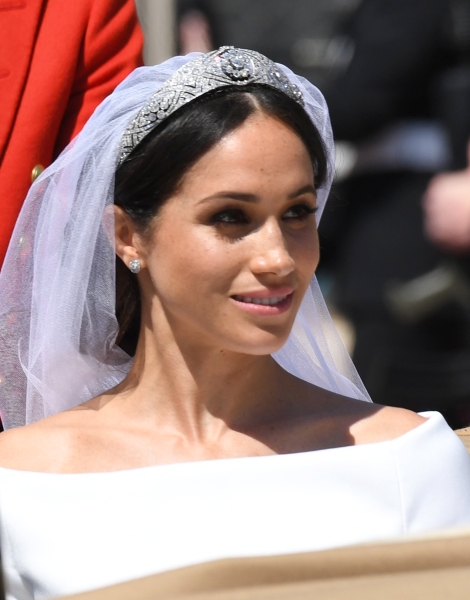 The Duke and Duchess of Sussex, Prince Harry and his new wife Meghan Markle smile and wave as they ride past the crowds on a horse drawn carriage in Windsor, UK.